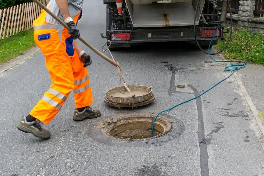 Blocked Drains plumber carrying out blocked drain clearing in Sutton